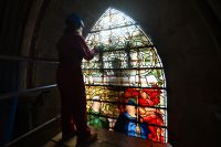 Glazier Kate Kersey prepares to remove the uppoer section of Angeli Ministrantes in the South Quire Aisle at Salisbury Cathedral photo Finnbarr Webster